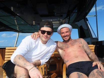 Brooklyn and David Beckham on a boat.