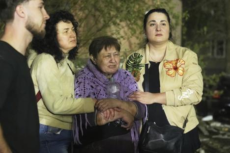 Residents react near a damaged apartment building in Kyiv, Ukraine.