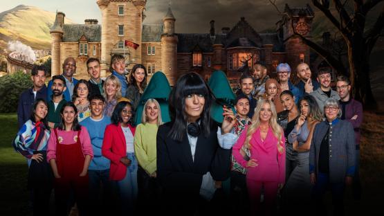 Group photo of the contestants of a reality show, in front of two castles.