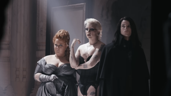 three women are standing next to each other and one has a tattoo on her arm