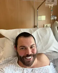 Man smiling in a hospital bed.