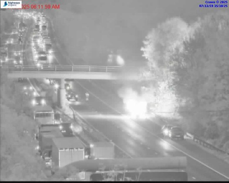 Night vision camera footage showing a highway accident with fire.