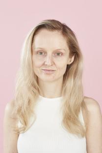 Woman with blonde hair and no makeup.
