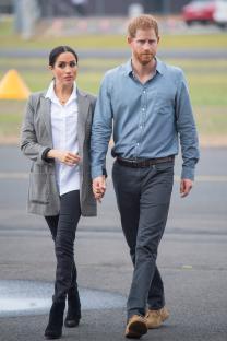 Meghan Markle and Prince Harry holding hands and walking.