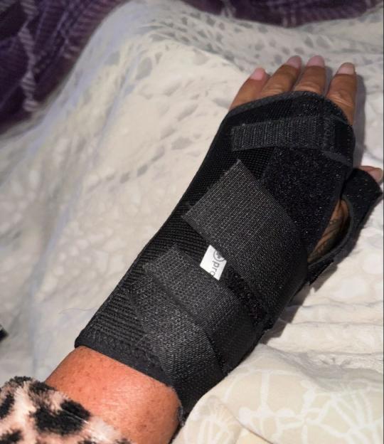 A person's arm wearing a black wrist brace.