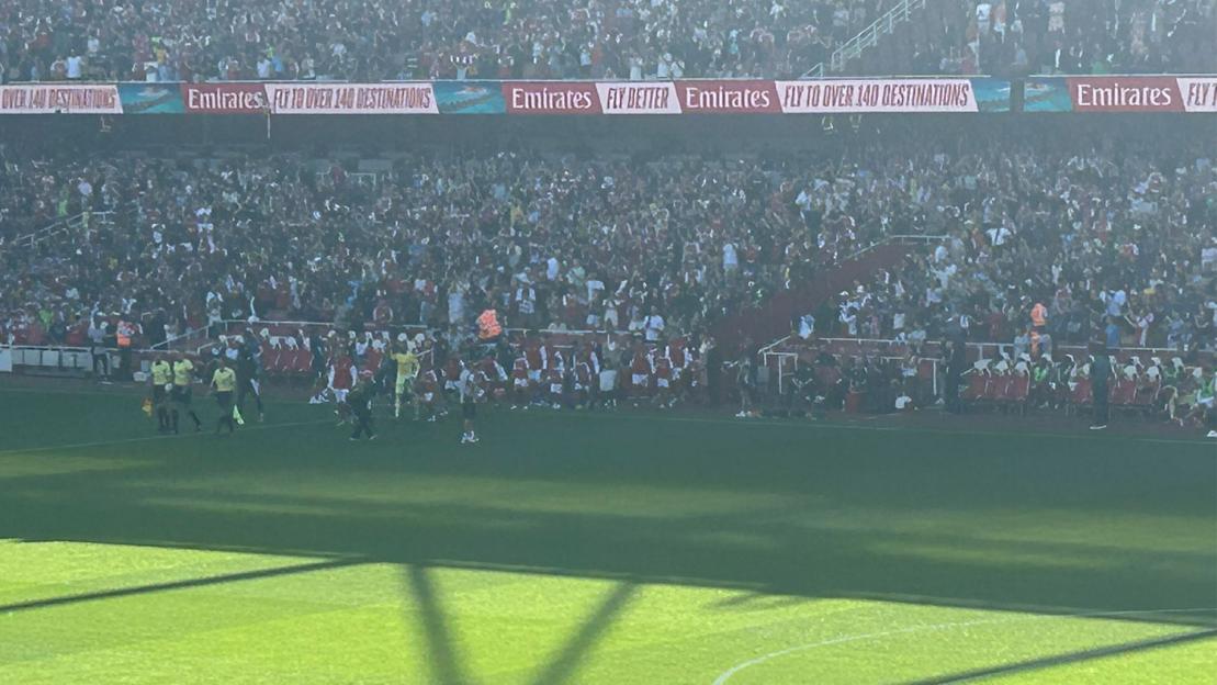 Soccer players and cheering fans at a stadium.