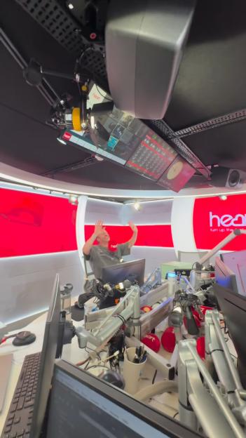 Mark Wright reacting in the Heart radio studio with his hands up.