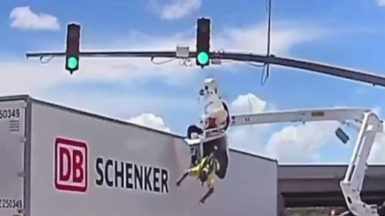 Horror moment worker is smashed into by huge 18-wheeler leaving him dangling from basket upside down above busy road