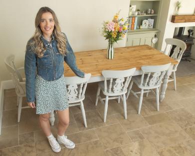 Woman standing by a farmhouse table.
