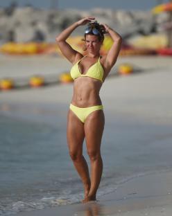 Rebecca Vardy in a yellow bikini on a beach.