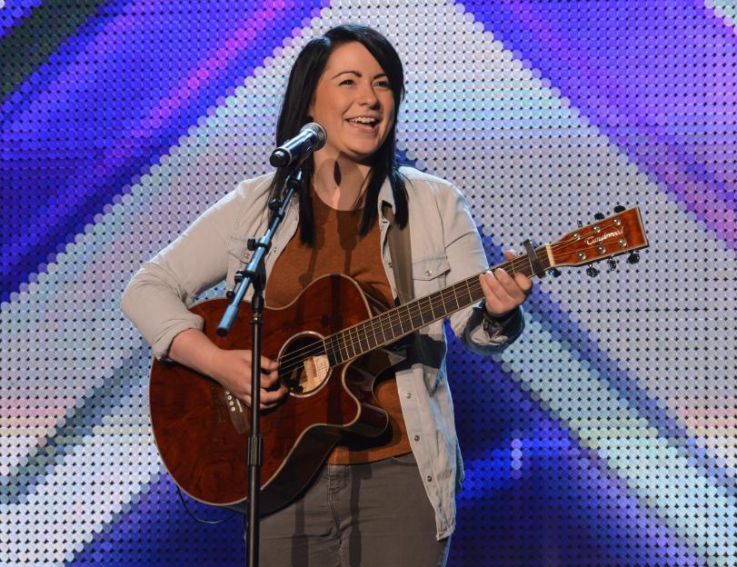Lucy Spraggan playing guitar and singing.