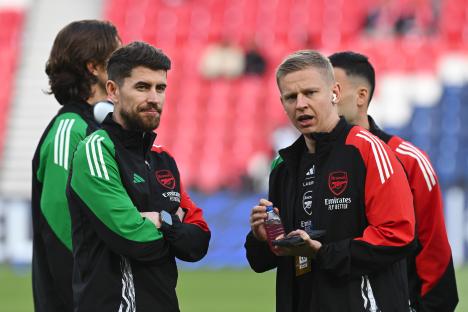 Arsenal coaches inspecting the pitch.