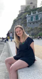 Woman sitting on a wall, before weight loss jabs.