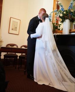 A bride and groom kissing at their wedding ceremony.