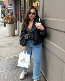 Woman holding Magnolia Bakery bag and ice cream.
