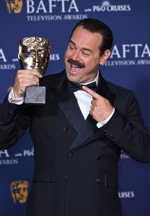 Danny Dyer holding a BAFTA Television Award.