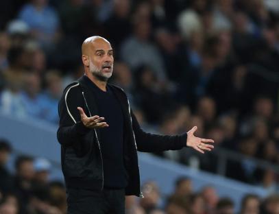 Pep Guardiola gesturing during a soccer match.