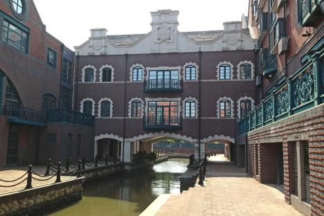 A canal runs between brick buildings designed to resemble an English town.