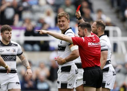 Rugby referee showing a red card to a player.