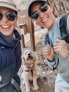 Two women and their dog on a hike.