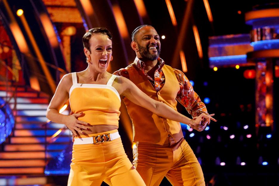 Lauren Oakley and JB Gill performing a dance in orange outfits on Strictly Come Dancing.