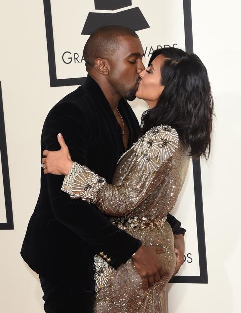 Kanye West and Kim Kardashian kissing at the 57th Annual GRAMMY Awards.