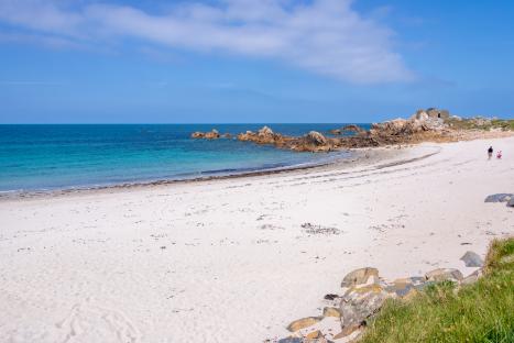 Jaonneuse Bay, Guernsey: a sandy beach with turquoise water and rocky outcrops.