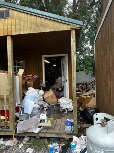 Overfilled shed with junk overflowing onto the porch.