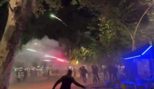Real Betis and Fiorentina fans clashing, fireworks and smoke.
