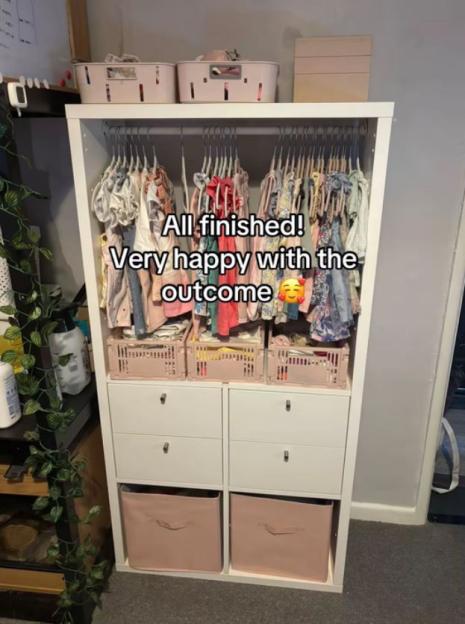 Baby clothes organized in a white wardrobe.
