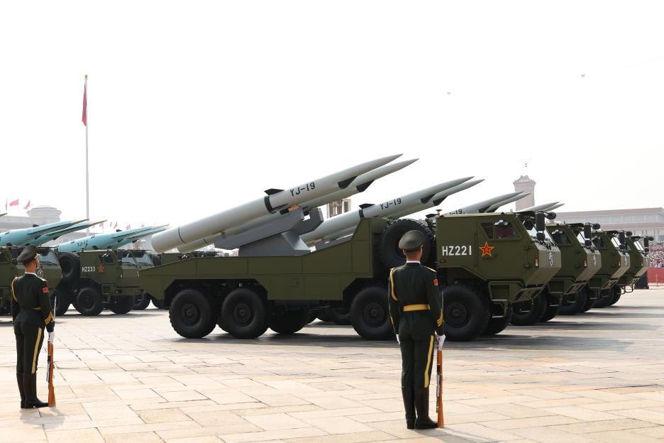 Military parade in Tiananmen Square with missile launchers and soldiers.