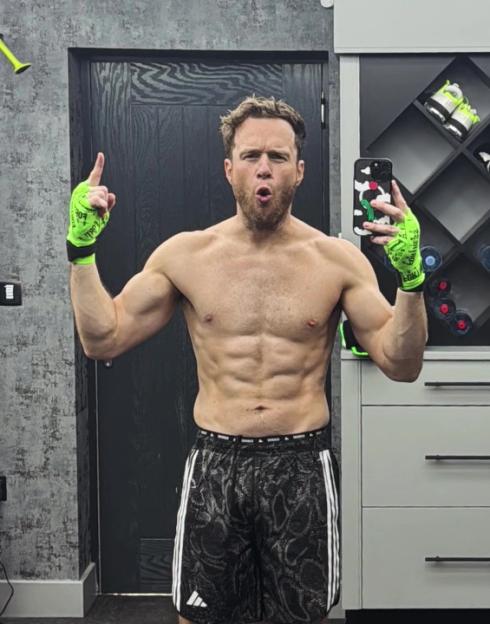 Olly Murs showing off his abs in his home gym.