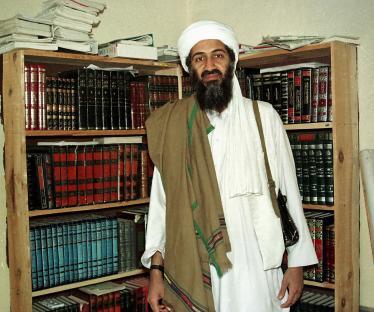 Osama bin Laden standing in front of bookshelves.