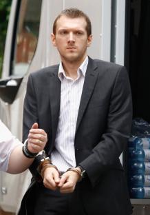 A man in handcuffs arriving at court for sentencing.