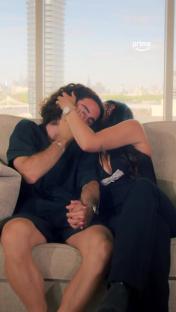 Marc Cucurella and Claudia Rodriguez embrace on a couch, he wipes away tears.