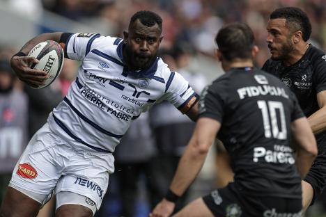 Rugby player running with the ball during a match.