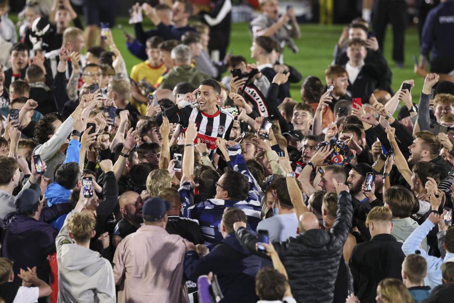 Jaze Kabia of Grimsby Town celebrates with fans.