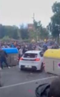 Car driving into a crowd of people.