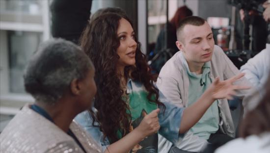 Jade Thirlwall speaking with a group of people.
