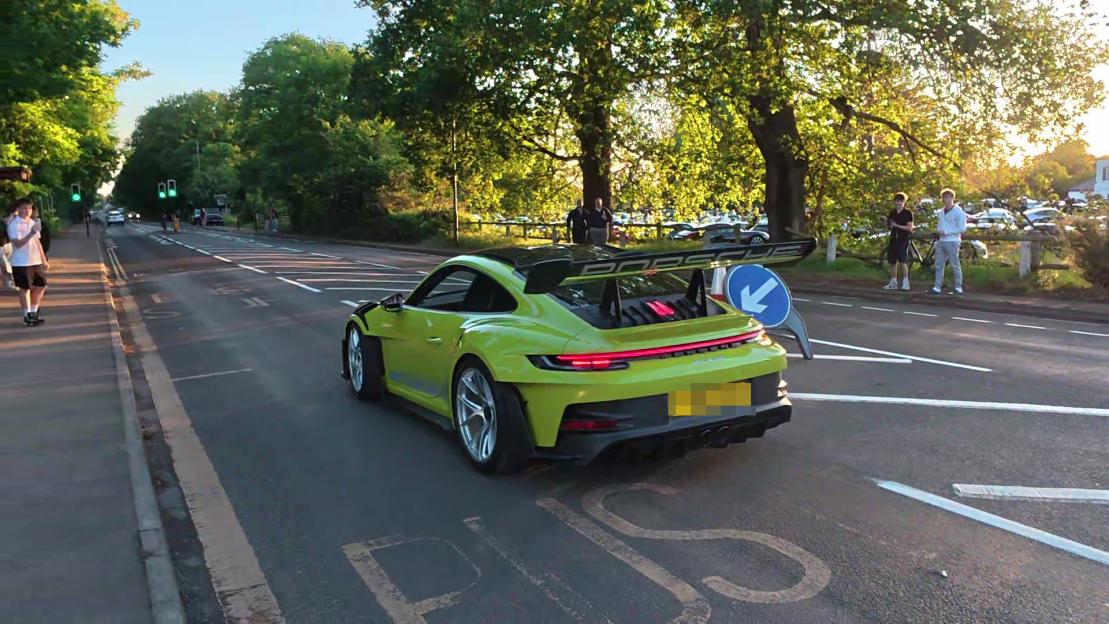 Robert Sanchez's green Porsche driving on a road.