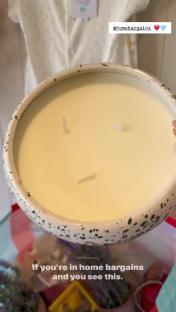 Large candle in speckled bowl.