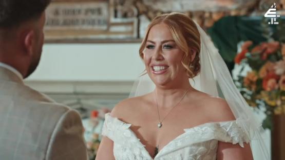A bride smiling at her groom during their wedding ceremony.