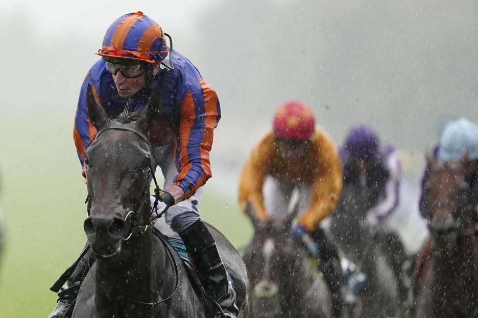 Jockey Ryan Moore riding a horse in the rain.